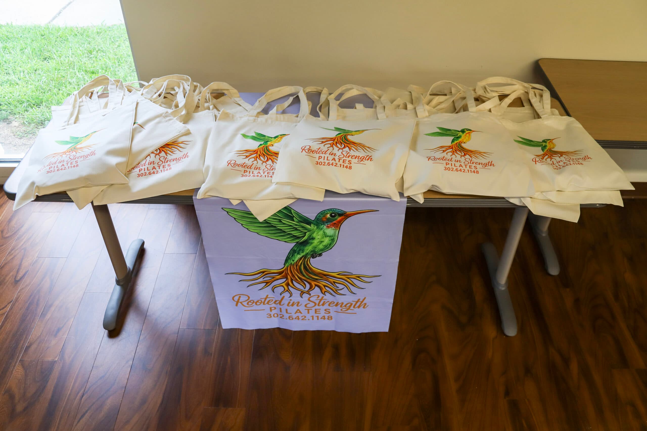 Rooted in Strength Pilates branded tote bags at a community event in Seaford, DE