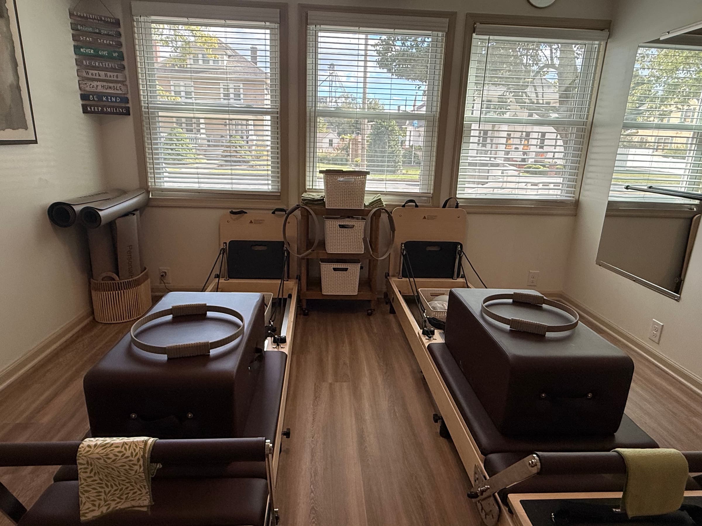 Two Pilates reformers facing the windows at the Rooted in Strength Pilates studio in Seaford, DE